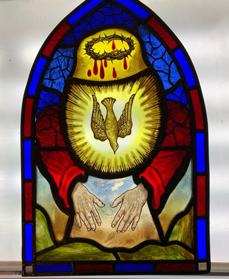Stained glass religious panel with dove, crown of thorns, and outstretched hands